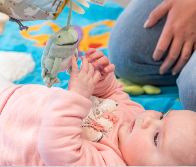 Baby-grijpend-naar-speelgoed