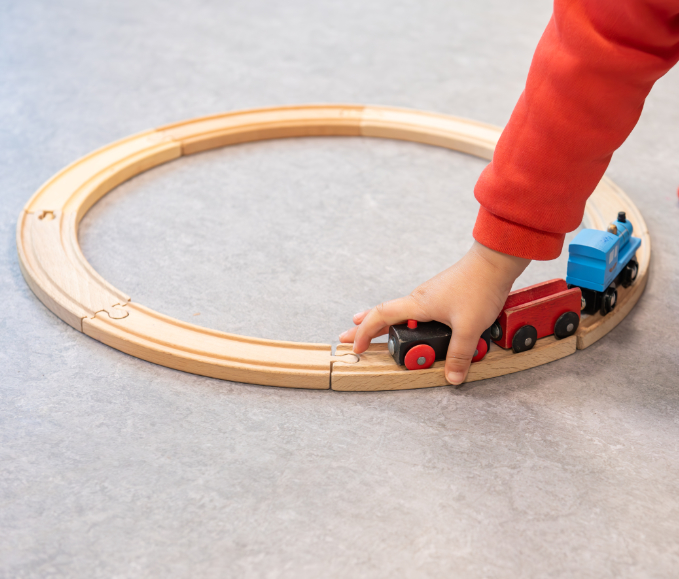 Kind-spelend-houten-trein-rond